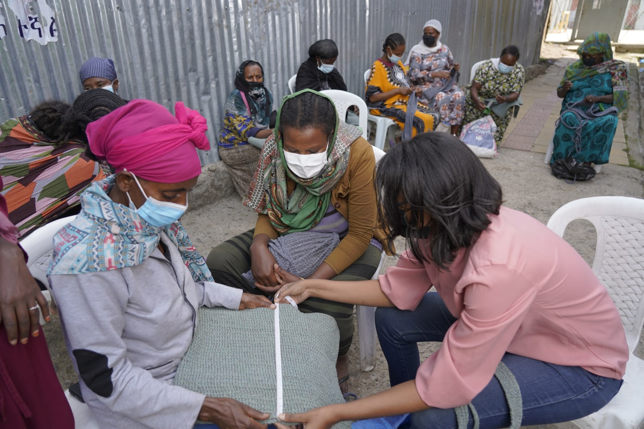 Kidist Gebrewold helping a Tuba Ethiopia employee make a bag