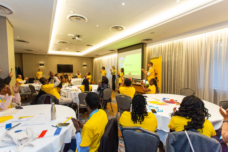 One Young World round table workshop workshop session showing attendees in yellow shirts