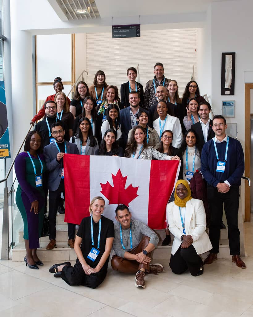 OYW attendees at the 2023 Summit in a group photo holding a Canadian national flag