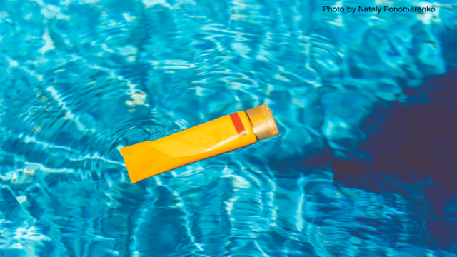 Sunscreen bottle floating in pool 