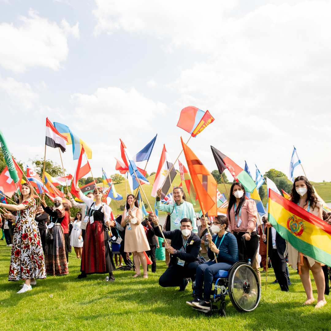 One Young World 2021 Flagbearers pose for a photo holding their respective flag at Munich's Olympic Park.