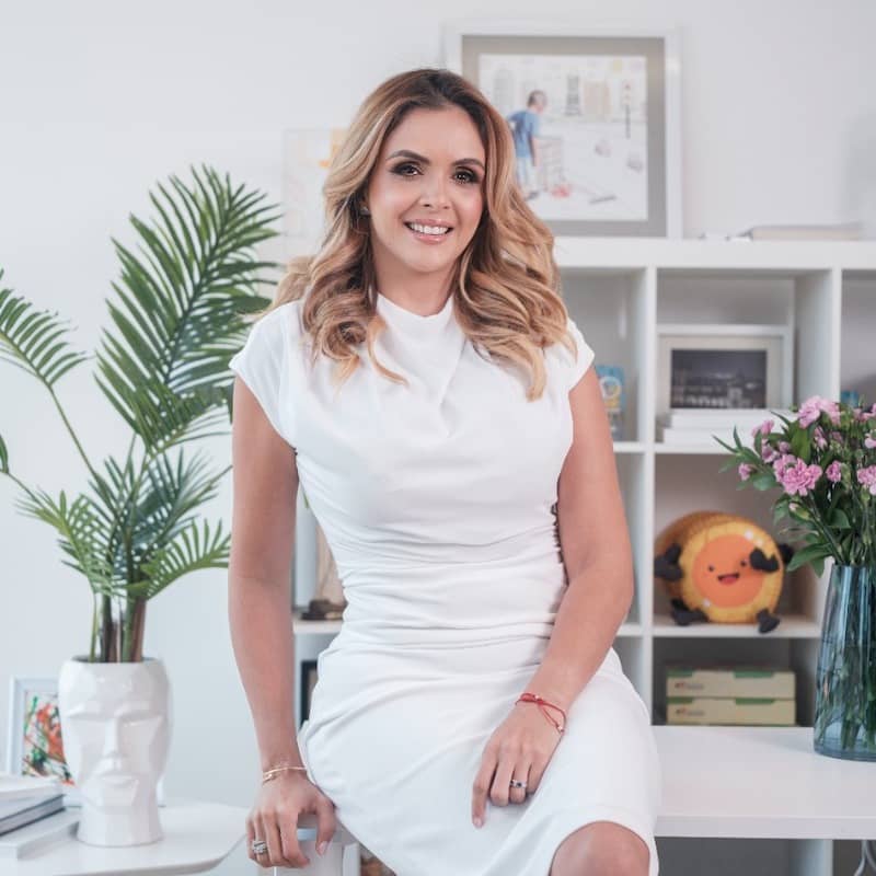 Portrait of María Claudia García Navarro in white dress in office background