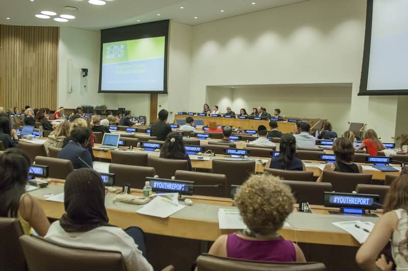 UN meeting with delegates sitting in concentric circle pattern facing the stage