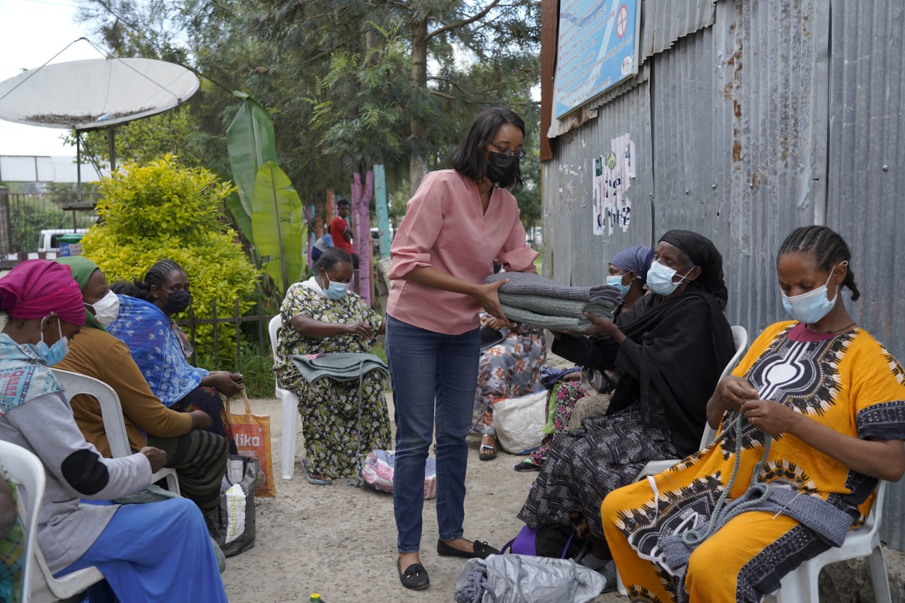 Kidist Gebrewold handing recycled material to Tuba Ethiopia workers to make into bags