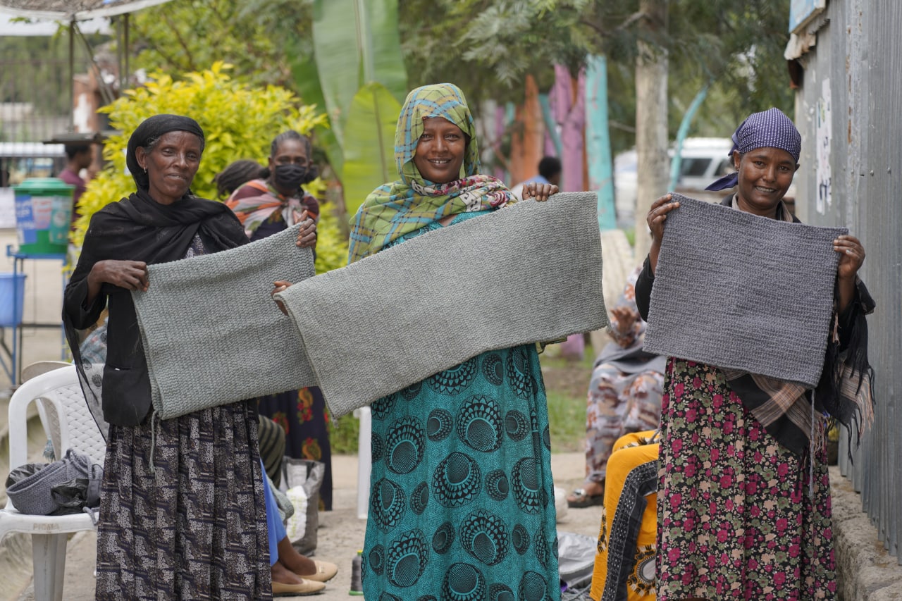 Three Tuba Ethiopia workers holding recycled material