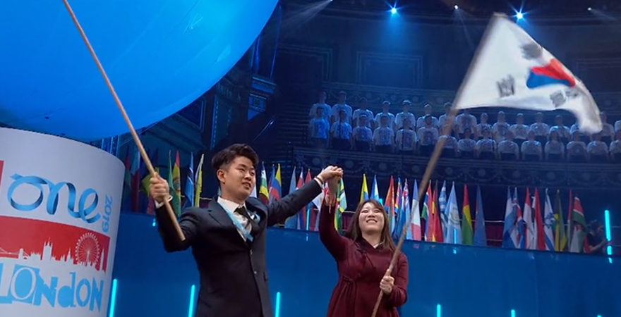 The flagbearers for North and South Korea holding hands.