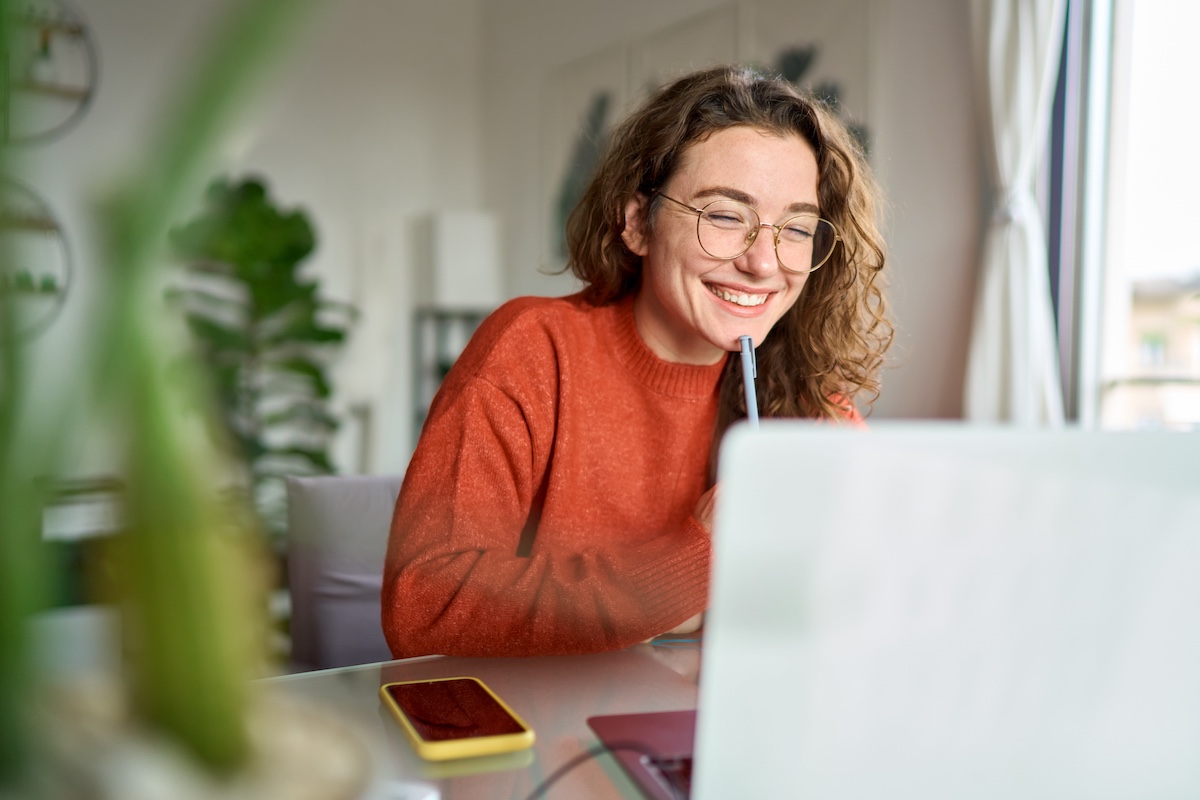 Female smiling in front of notebook laptop