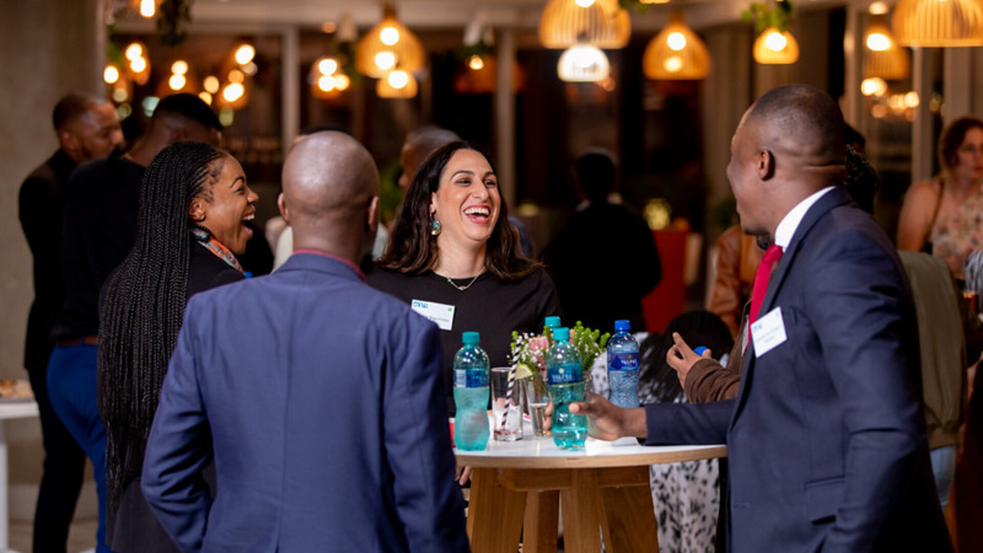 Two ladies and two gentlemen smartly dressed congregating around a standup table at the Reception at the South Africa Post-Summit
