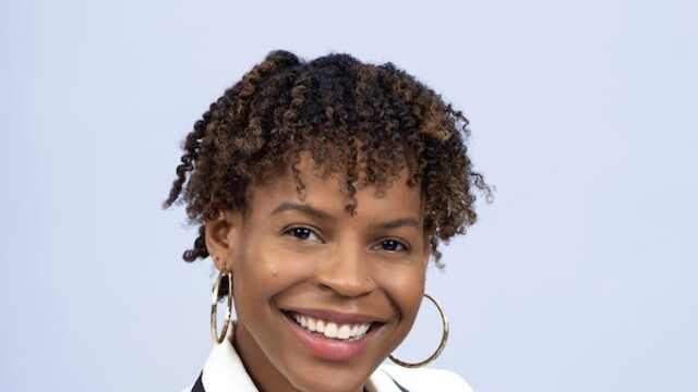 Lashyra Nolen en blazer blanc sur fond bleu clair