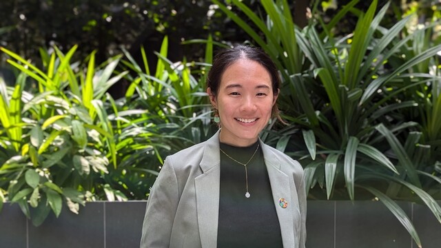 Samantha Thian in business attire, against lush green background