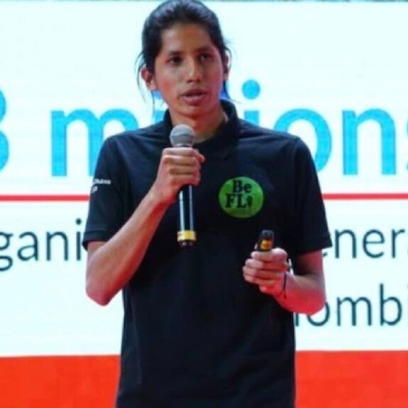 Jhoan Chávez in black polo shirt presenting on stage