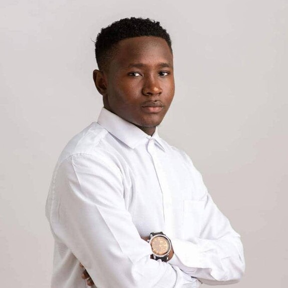 Clement Ngosong portrait in formal white shirt and wristwatch against beige background