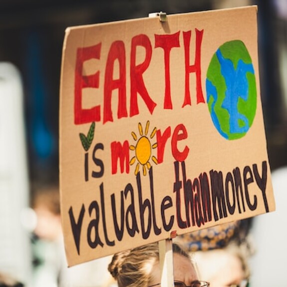 A protest placard that reads: "Earth is more valuable than money"