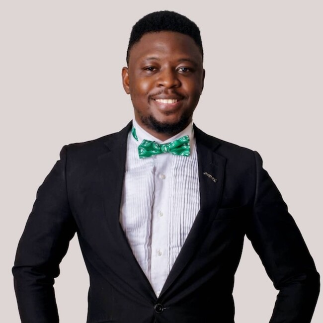 Portrait de Babatunde Adewumi portant une chemise blanche et un blazer noir