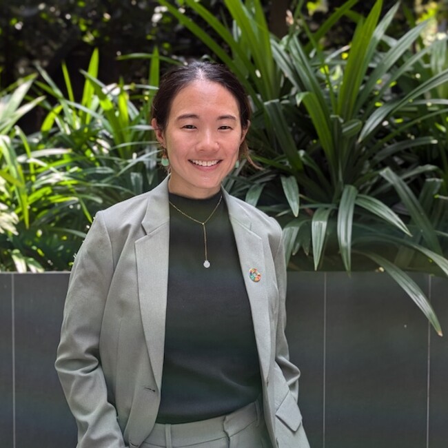 Samantha Thian in business attire, against lush green background