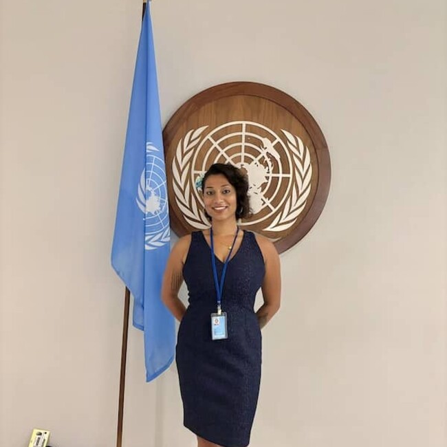 Serena Bashal posing next to the UN flag