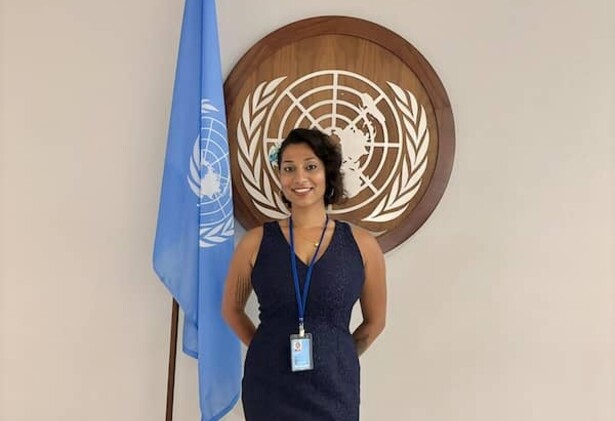 Serena Bashal posing next to the UN flag