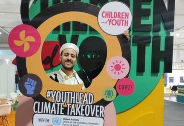 Saad Uakkas holding up a youth-lead Climate Takeover signage