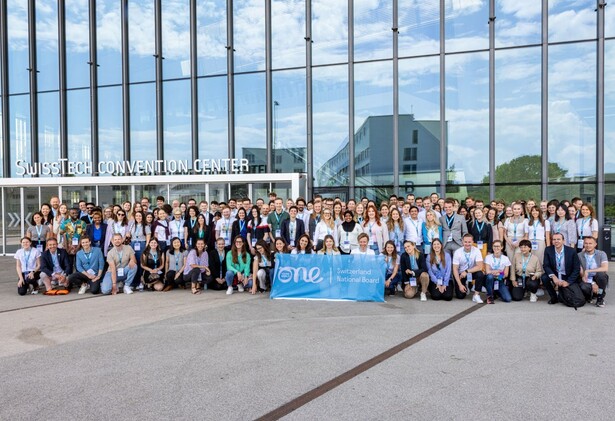 Swiss National Board members group photo outside the Swiss Tech Convention Centre holding a blue OYW banner