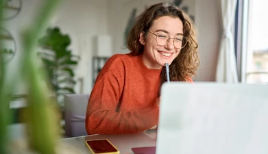 woman with glasses in frotn of computer screen