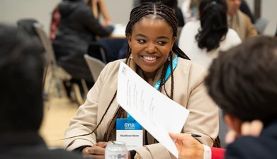 Delegate woman at the summit, sitting and smiling