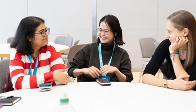 three women sitting at. a table smiling