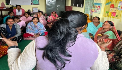 an educator speaks to a group of women in nepal