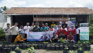 a group of people stands in front of potted plants