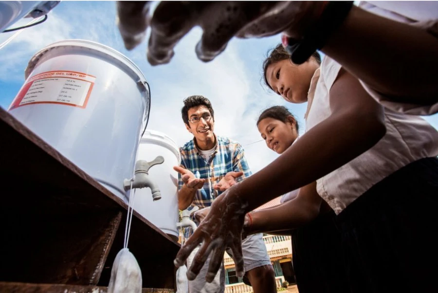 Samir Lakhani teaching a group of children about handwashing