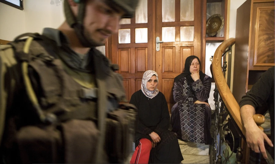 women sitting on stairs and military men on site
