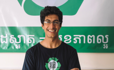 Samir Lakhani smiling in front of an Eco-Soap Bank sign