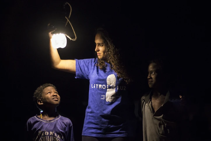 Image of Ambassador with children and a Litro de Luz light