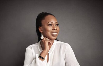 Aminka Portrait, wearing white top against grey black background