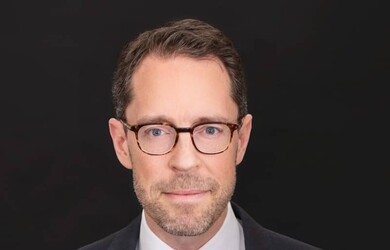 Gregoire portrait wearing formal attire against black background
