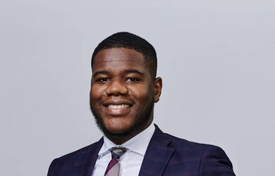 Kevin portrait wearing formal attire against light grey background