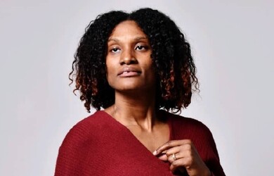 Nerlande portrait wearing red top against grey background