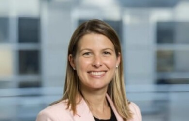 Samantha portrait wearing black undershirt and light pink blazer against building background