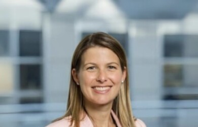 Samantha portrait wearing black undershirt and light pink blazer against building background