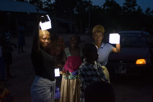 A group of women hold solar lights