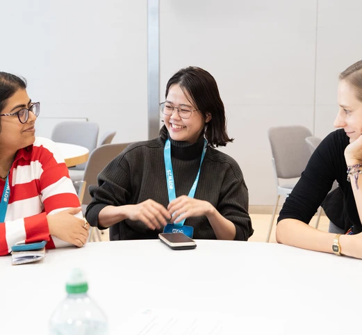 three women sitting at. a table smiling