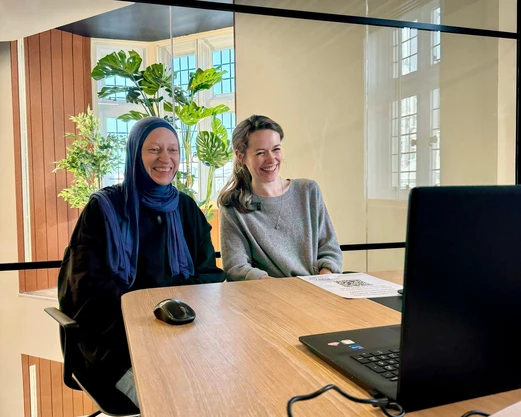 Giselle and Olena, another EqualReach team member, sit smiling