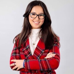 Portrait of Amira Affaf in patterned red blazer against grey background