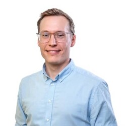 Dr. Lukas Schertel wearing casual sky blue shirt against white background