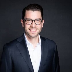 Felix Wolfensberger wearing formal attire against black background