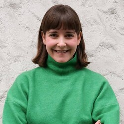 Joëlle Frank portrait wearing green turtleneck jumper against textured beige background