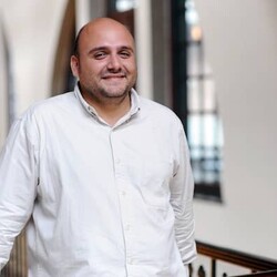 Portrait of Stephan Mario in white casual shirt against indoor background